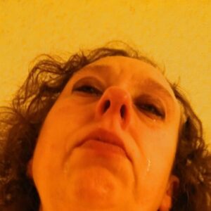 Femme laide visage en gros plan a Villiers sur Marne avec levres entrouvertes et double menton visible cheveux bruns ondules laches traits marques et regard serieux 2