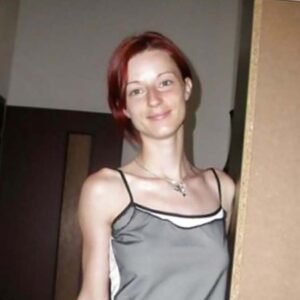 Femme mince avec poitrine visible sous debardeur gris visage clair