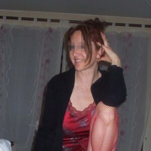 Femme mure de Beaune souriante silhouette voluptueuse aux courbes naturelles et poitrine genereuse portant robe satinee rouge et bas resille cheveux roux en chignon lache 2